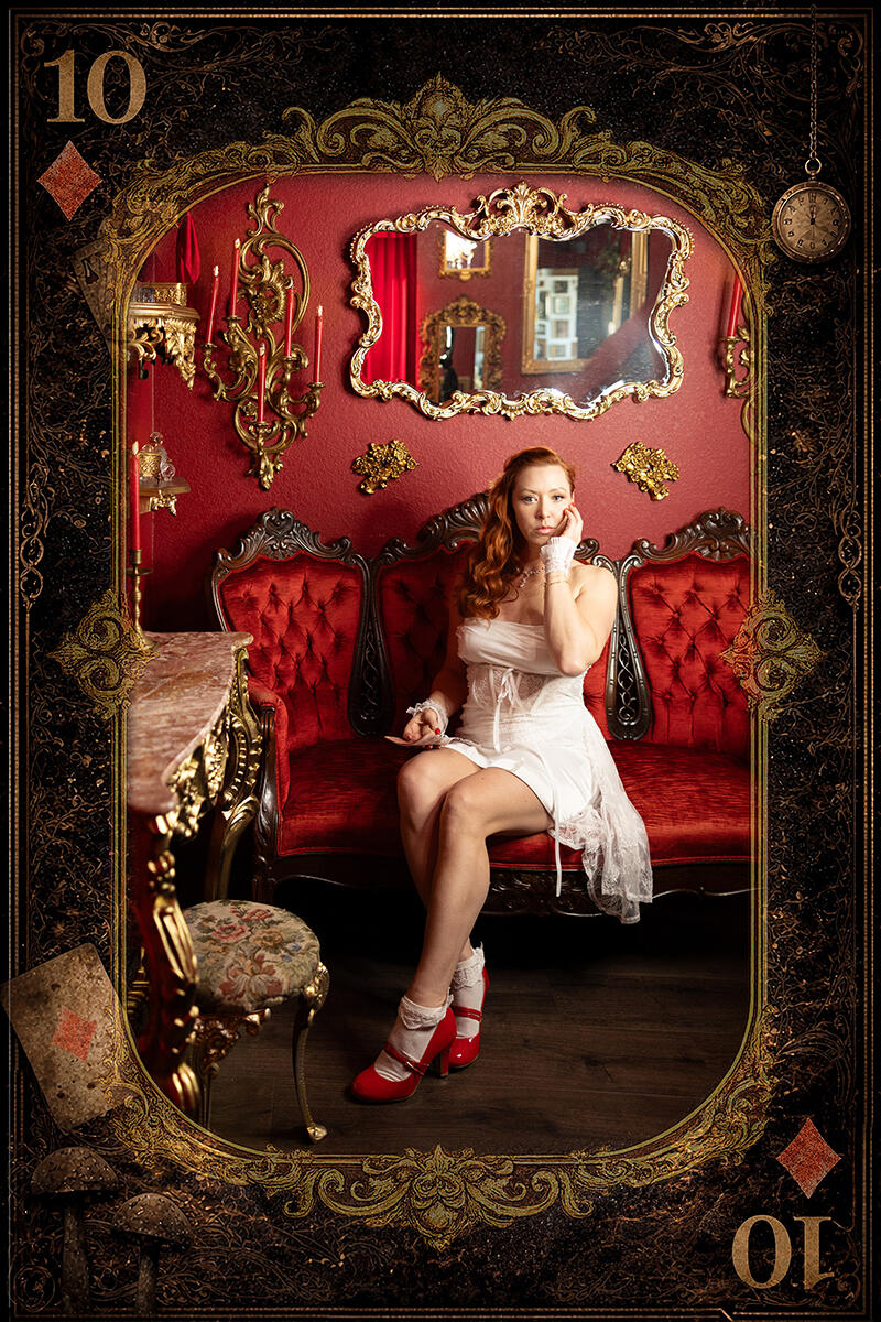 Ten of Diamonds Fine-Art Portrait Woman in a white dress and red heels seated on a red velvet sofa within an ornate Ten of Diamonds playing-card design.
